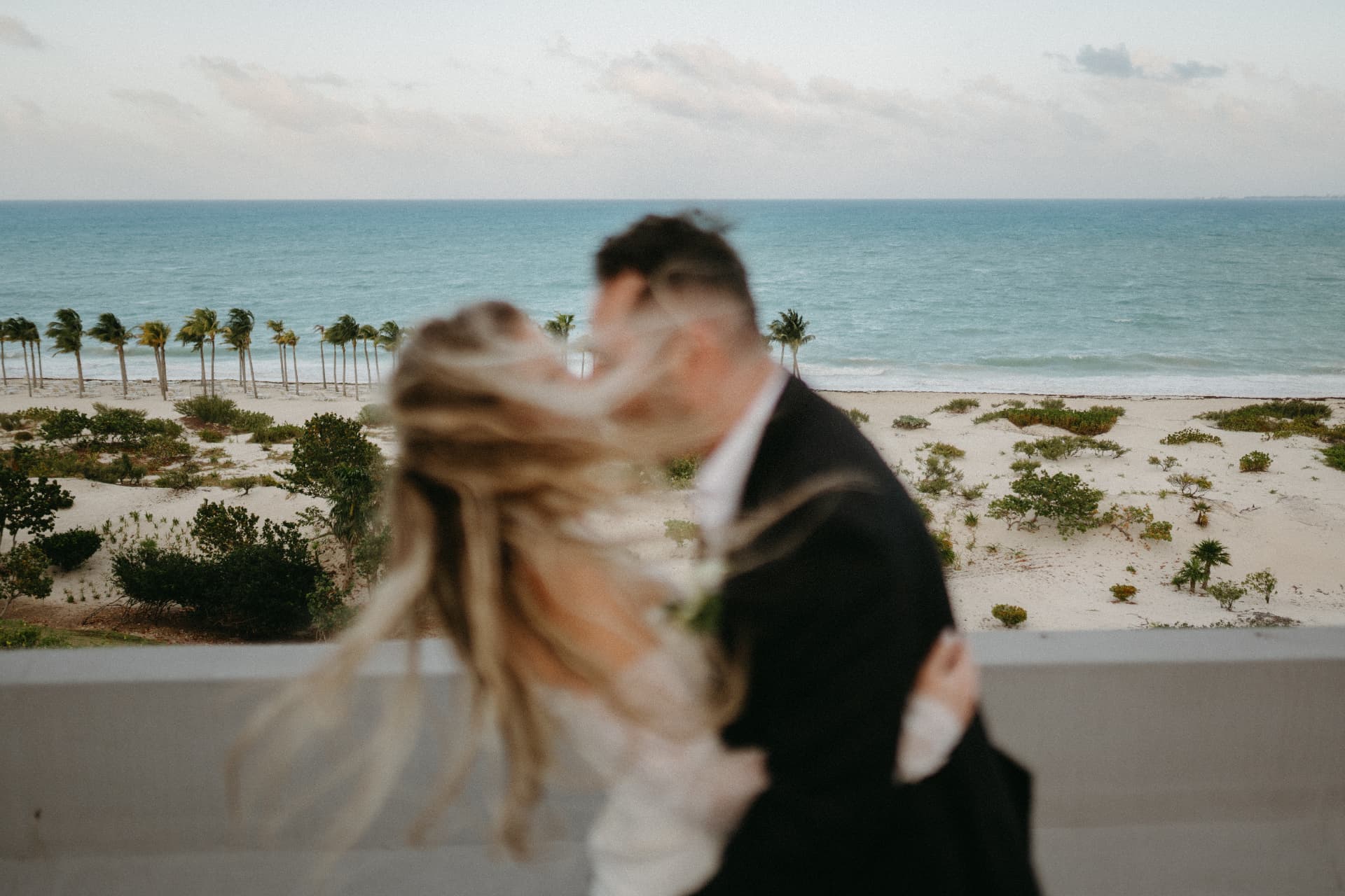Novios besándose frente al mar